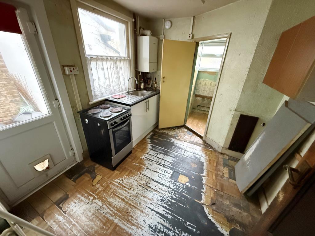 Lot: 125 - MID-TERRACE HOUSE FOR IMPROVEMENT - Kitchen with window and back door